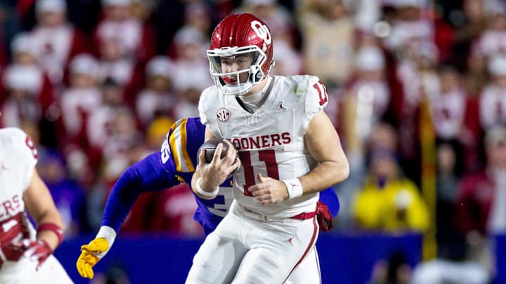 Nov 30, 2024; Baton Rouge, Louisiana, USA;  Oklahoma Sooners quarterback Jackson Arnold (11) is tackled by LSU Tigers defensive end Sai'vion Jones (35) during the second quarter at Tiger Stadium.