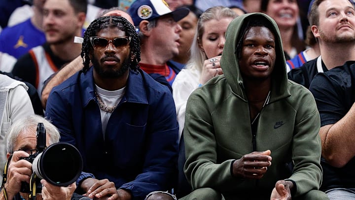 Oct 24, 2023; Denver, Colorado, USA; University of Colorado Buffaloes football players Shedeur Sanders (L) and Travis Hunter (R) watch during the third period between the Denver Nuggets and the Los Angeles Lakers at Ball Arena. 