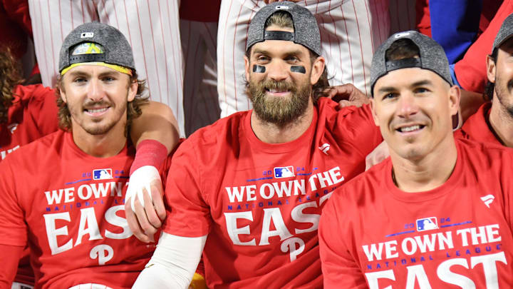  Philadelphia Phillies second base Bryson Stott (5), first baseman Bryce Harper (3) and catcher J.T. Realmuto (10) celebrate the National League East Division title at Citizens Bank Park.