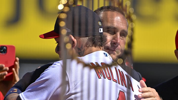 Oct 2, 2022; St. Louis, Missouri, USA;  St. Louis Cardinals catcher Yadier Molina (4) hugs John Mozeliak during a farewell ceremony for Molina and first baseman Albert Pujols (5) before a game against the Pittsburgh Pirates at Busch Stadium. Mandatory Credit: Jeff Curry-Imagn Images