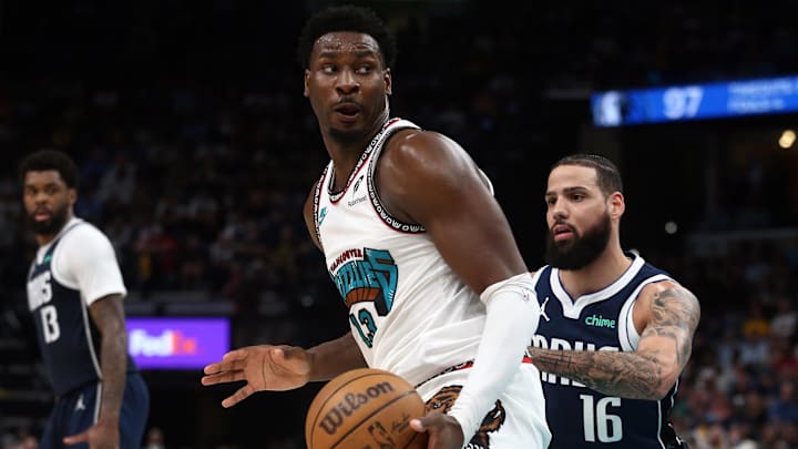 Apr 18, 2025; Memphis, Tennessee, USA; Memphis Grizzlies forward Jaren Jackson Jr. (13) spins to the basket against Dallas Mavericks forward Caleb Martin (16) during the fourth quarter at FedExForum. Mandatory Credit: Petre Thomas-Imagn Images