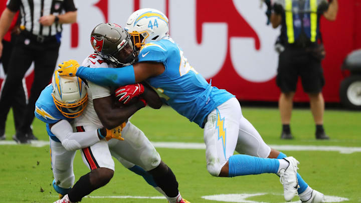 Oct 4, 2020; Tampa, Florida, USA; Tampa Bay Buccaneers running back Ronald Jones (27) is tackled by Los Angeles Chargers outside linebacker Kyzir White (44) and cornerback Michael Davis (43) in the first quarter of a NFL game at Raymond James Stadium. Mandatory Credit: Kim Klement-Imagn Images