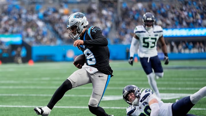 Carolina Panthers quarterback Bryce Young (9) scores a ten-yard rushing touchdown against Seattle Seahawks safety Ty Okada 