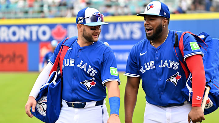 Feb 25, 2025; Dunedin, Florida, USA; Toronto Blue Jays shortstop Bo Bichette (11)  and designated hitter Vladimir Guerrero Jr. (27) walk towards the dugout before a spring training game against the St. Louis Cardinals  at TD Ballpark. Mandatory Credit: Jonathan Dyer-Imagn Images