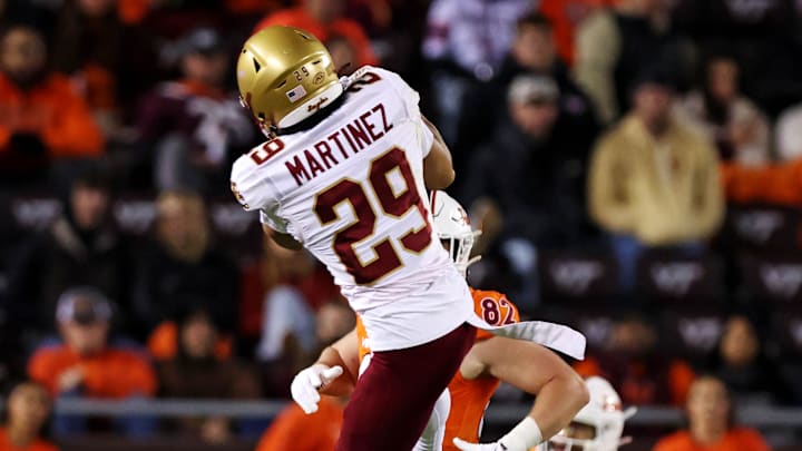 Oct 17, 2024; Blacksburg, Virginia, USA; Boston College Eagles defensive back Cameron Martinez (29) intercepts a pass by Virginia Tech Hokies quarterback Kyron Drones (1) during the third quarter at Lane Stadium. Mandatory Credit: Peter Casey-Imagn Images