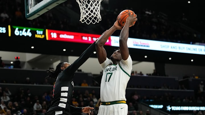 Jan 7, 2025; Waco, Texas, USA;  Baylor Bears forward Josh Ojianwuna (17) scores a basket as Cincinnati Bearcats guard Day Day Thomas (1) defends during the first half at Paul and Alejandra Foster Pavilion. Mandatory Credit: Chris Jones-Imagn Images