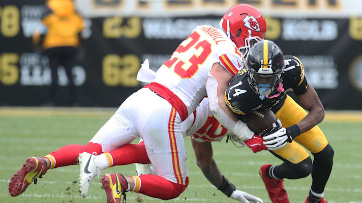Dec 25, 2024; Pittsburgh, Pennsylvania, USA;  Pittsburgh Steelers wide receiver George Pickens (14) is tackled after a catch by Kansas City Chiefs linebacker Drue Tranquill (23) and safety Justin Reid (20) during the second quarter at Acrisure Stadium. Mandatory Credit: Charles LeClaire-Imagn Images