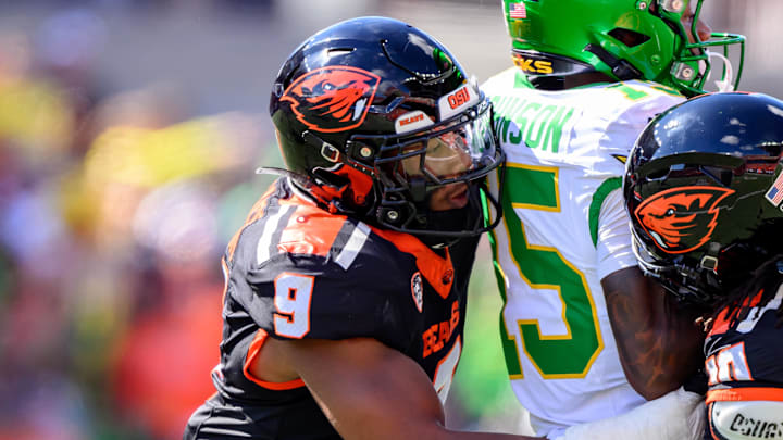 Sep 14, 2024; Corvallis, Oregon, USA; Oregon State Beavers linebacker Isaiah Chisom (9) and defensive back Josiah Johnson (30) tackle Oregon Ducks wide receiver Tez Johnson (15) after a catch during the second half at Reser Stadium. Mandatory Credit: Craig Strobeck-Imagn Images