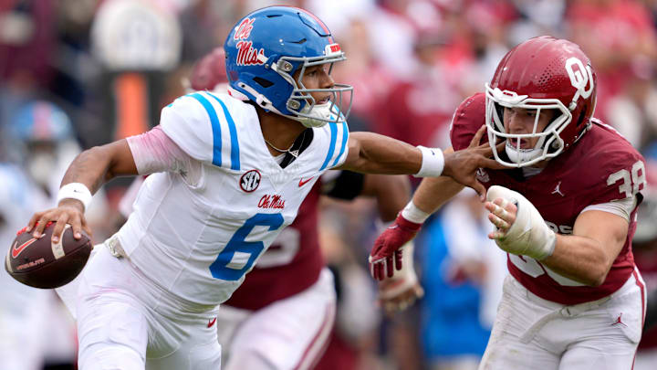 Ole Miss quarterback Trinidad Chambliss tries to hold off Oklahoma linebacker Owen Heinecke.