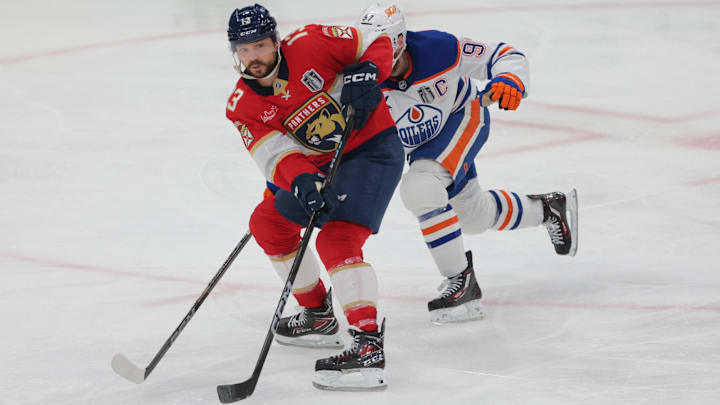 Jun 12, 2025; Sunrise, Florida, USA; Florida Panthers forward Sam Reinhart (13) passes the puck against Edmonton Oilers center Connor McDavid (97) during the third period in game four of the 2025 Stanley Cup Final at Amerant Bank Arena. Mandatory Credit: Sam Navarro-Imagn Images