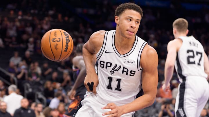 Nov 2, 2025; Phoenix, Arizona, USA; San Antonio Spurs forward Carter Bryant (11) reacts after scores during the second half against the Phoenix Suns at Mortgage Matchup Center.