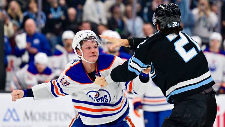 Oct 17, 2026; Salt Lake City, Utah, USA;  Edmonton Oilers center Trent Frederic (10) and Utah Mammoth center Jack McBain (22) take turns throwing punches during first period at Delta Center.  Mandatory Credit: Peter Creveling-Imagn Images