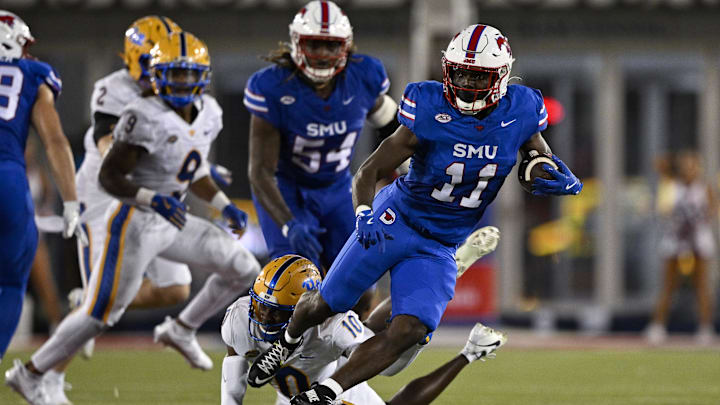 SMU Mustangs running back LJ Johnson Jr. and Pittsburgh Panthers defensive back Ryland Gandy in action during a game.
