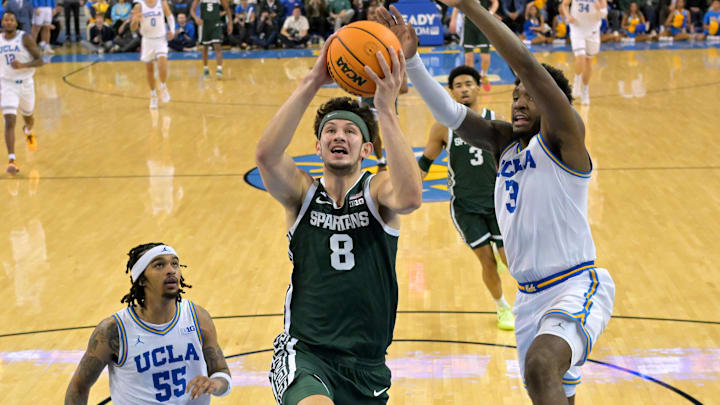 Feb 4, 2025; Los Angeles, California, USA; Michigan State Spartans forward Frankie Fidler (8) drives past UCLA Bruins guard Skyy Clark (55) and guard Eric Dailey Jr. (3) in the second half at Pauley Pavilion presented by Wescom. Mandatory Credit: Jayne Kamin-Oncea-Imagn Images