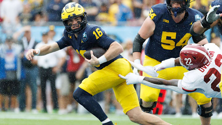 Dec 31, 2024; Tampa, FL, USA; Michigan Wolverines quarterback Davis Warren (16) scrambles with the ball away from Alabama Crimson Tide defensive lineman LT Overton (22) during the first half at Raymond James Stadium. Mandatory Credit: Matt Pendleton-Imagn Images Dec 31, 2024; Tampa, FL, USA; Michigan Wolverines quarterback Davis Warren (16) scrambles with the ball away from Alabama Crimson Tide defensive lineman LT Overton (22) during the first half at Raymond James Stadium. Mandatory Credit: Matt Pendleton-Imagn Images