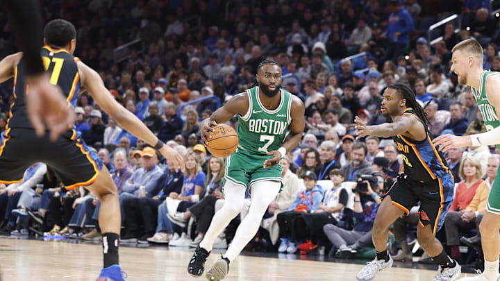 Jan 5, 2025; Oklahoma City, Oklahoma, USA; Boston Celtics guard Jaylen Brown (7) dribbles the ball between Oklahoma City Thunder guard Aaron Wiggins (21) and guard Cason Wallace (22) during the second quarter at Paycom Center. Mandatory Credit: Alonzo Adams-Imagn Images