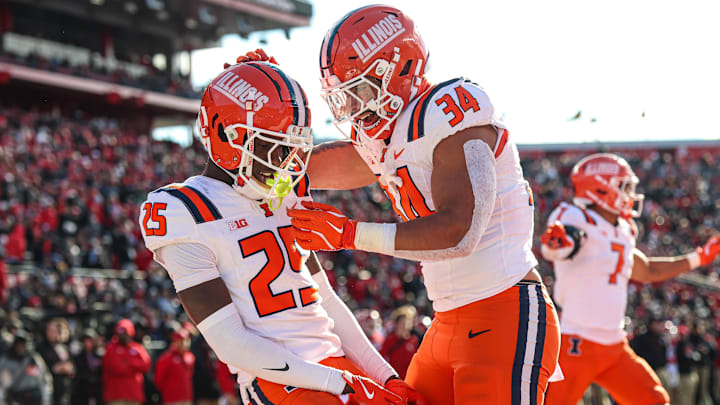 Nov 23, 2024; Piscataway, New Jersey, USA; Illinois Fighting Illini defensive back Jaheim Clarke (25) celebrates a defensive stop with linebacker Ryan Meed (34) during the first half against the Rutgers Scarlet Knights at SHI Stadium. Mandatory Credit: Vincent Carchietta-Imagn Images