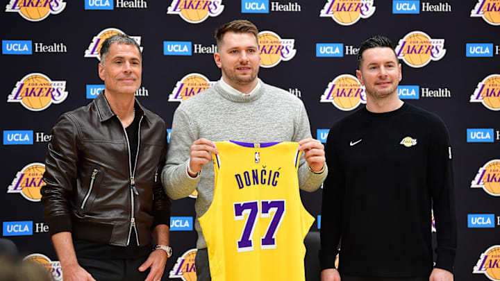 Los Angeles Lakers guard Luka Doncic poses for photos with general manager Rob Pelinka and coach JJ Redick.