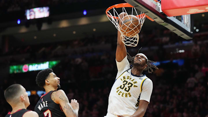 Jan 2, 2025; Miami, Florida, USA;  Indiana Pacers center Myles Turner (33) dunks as Miami Heat center Kel'el Ware (7) and guard Tyler Herro (14) look on during the first half at Kaseya Center. Mandatory Credit: Jim Rassol-Imagn Images