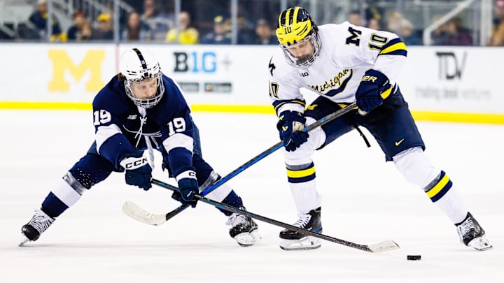 Mar 7, 2025; Ann Arbor, MI, USA;  Michigan Wolverines forward Thomas Daskas (10) skates with the puck defended by Penn State forward Dane Dowiak (19) in the third period of a Big Ten Tournament quarter final game at Yost Arena. Mandatory Credit: Rick Osentoski-Imagn Images