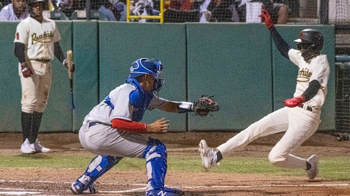 Visalia Rawhide's Alvin Guzman scores ahead of the tag by Rancho Cucamonga's Thayron Liranzo on Tuesday, April 11, 2023 during Rawhide's home opener.