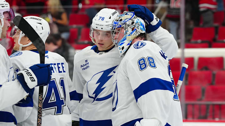 Oct 11, 2024; Raleigh, North Carolina, USA;  Tampa Bay Lightning goaltender Andrei Vasilevskiy (88) and defenseman Emil Lilleberg (78) celebrate their victory against the Carolina Hurricanes at PNC Arena. Mandatory Credit: James Guillory-Imagn Images