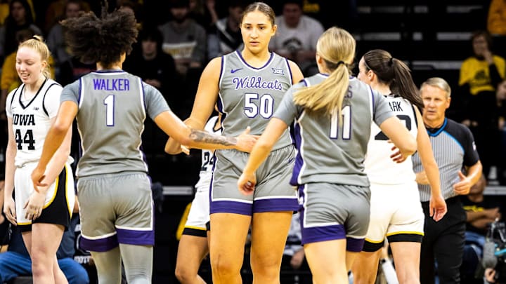Kansas State center Ayoka Lee (50) is greeted by teammates Zyanna Walker, left, and Taryn Sides, right, on the court.