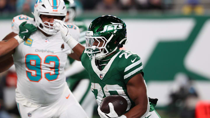 Jan 5, 2025; East Rutherford, New Jersey, USA; New York Jets running back Breece Hall (20) runs with the ball while being pursued by Miami Dolphins defensive tackle Calais Campbell (93) during the second quarter at MetLife Stadium. Mandatory Credit: Ed Mulholland-Imagn Images Jan 5, 2025; East Rutherford, New Jersey, USA; New York Jets running back Breece Hall (20) runs with the ball while being pursued by Miami Dolphins defensive tackle Calais Campbell (93) during the second quarter at MetLife Stadium. Mandatory Credit: Ed Mulholland-Imagn Images