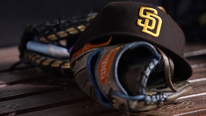 A San Diego Padres hat and glove in the dugout prior to the game between the Miami Marlins and the San Diego Padres at loanDepot park on July 23, 2021.