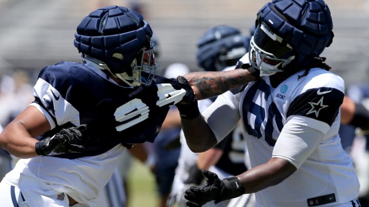 Jul 30, 2024; Oxnard, CA, USA; Dallas Cowboys defensive end Marshawn Kneeland (94) and offensive tackle Tyler Guyton (60) battle during training camp at the River Ridge Playing Fields in Oxnard, California. 