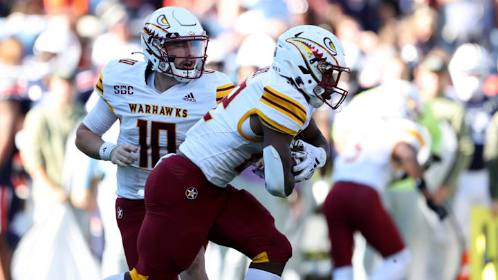 Nov 16, 2024; Auburn, Alabama, USA; Louisiana Monroe Warhawks quarterback Aidan Armenta (10) hands off to running back Ahmad Hardy (22) during the third quarter against the Auburn Tigers at Jordan-Hare Stadium. Mandatory Credit: John Reed-Imagn Images Nov 16, 2024; Auburn, Alabama, USA; Louisiana Monroe Warhawks quarterback Aidan Armenta (10) hands off to running back Ahmad Hardy (22) during the third quarter against the Auburn Tigers at Jordan-Hare Stadium. Mandatory Credit: John Reed-Imagn Images