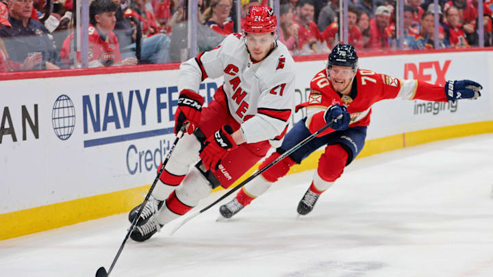 May 26, 2025; Sunrise, Florida, USA; Carolina Hurricanes defenseman Alexander Nikishin (21) controls the puck as Florida Panthers center Jesper Boqvist (70) defends during the second period in game four of the Eastern Conference Final of the 2025 Stanley Cup Playoffs at Amerant Bank Arena. Mandatory Credit: Sam Navarro-Imagn Images