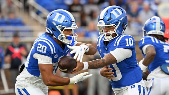 Nov 15, 2025; Durham, North Carolina, USA; Duke Blue Devils quarter back Darian Mensah (10) hands the ball to Duke Blue Devils running back Nate Sheppard (20) against the Virginia Cavaliers during the first quarter at Wallace Wade Stadium. Mandatory Credit: Zachary Taft-Imagn Images