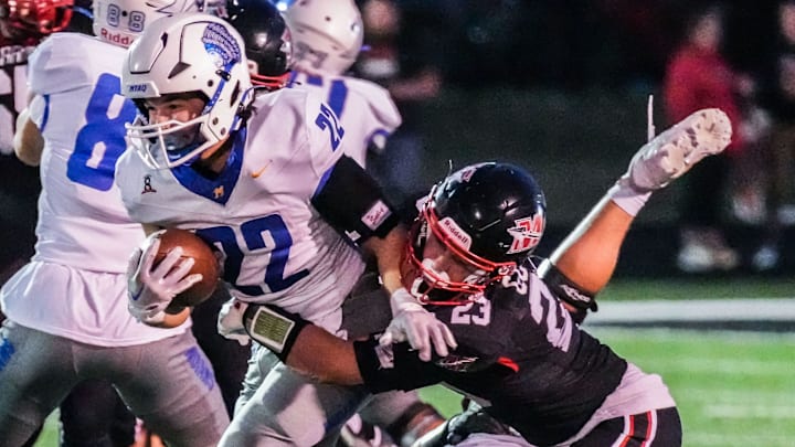 Muskego linebacker Thomas Gover (23) brings down Mukwonago running back Mason Radobicky (22) during the game at Muskego on Friday, Sept. 13, 2024.