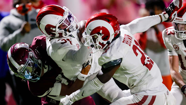 Owasso’s Peyton LeGrand (34) recovers a fumble and is taken down by Edmond Memorial’s Isaac Woodard (14) during a high school football game between Edmond Memorial and Owasso in Edmond, Okla. on Thursday, Oct. 17, 2024.