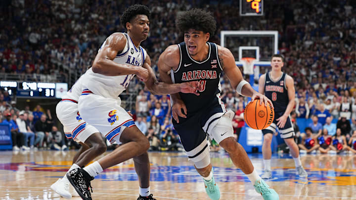 Feb 7, 2026; Lawrence, Kansas, USA; Arizona Wildcats forward Koa Peat (10) drives against Kansas Jayhawks forward Bryson Tiller (15) during the first half at Allen Fieldhouse. Mandatory Credit: Jay Biggerstaff-Imagn Images