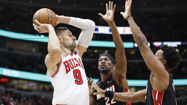 Nov 20, 2023; Chicago, Illinois, USA; Chicago Bulls center Nikola Vucevic (9) looks to pass the ball against Miami Heat forward Jimmy Butler (22) and guard Kyle Lowry (7) during the first half at United Center. Mandatory Credit: Kamil Krzaczynski-Imagn Images