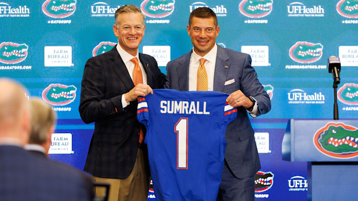 Dec 1, 2025; Gainesville, FL, USA; Florida Gators athletic director Scott Stricklin and Florida Gators head coach Jon Sumrall poses with a Florida Gators jersey during the press conference at the Heavener Football Training Center at the University of Florida. Mandatory Credit: Matt Pendleton-Imagn Images