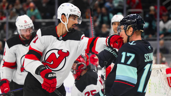 Jan 6, 2025; Seattle, Washington, USA; New Jersey Devils defenseman Jonas Siegenthaler (71) punches Seattle Kraken center Jaden Schwartz (17) during the third period at Climate Pledge Arena. Mandatory Credit: Steven Bisig-Imagn Images