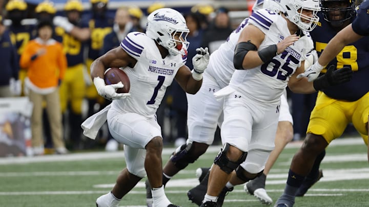 Nov 23, 2024; Ann Arbor, Michigan, USA;  Northwestern Wildcats running back Cam Porter (1) runs the ball against the Michigan Wolverines in the first half at Michigan Stadium. Mandatory Credit: Rick Osentoski-Imagn Images