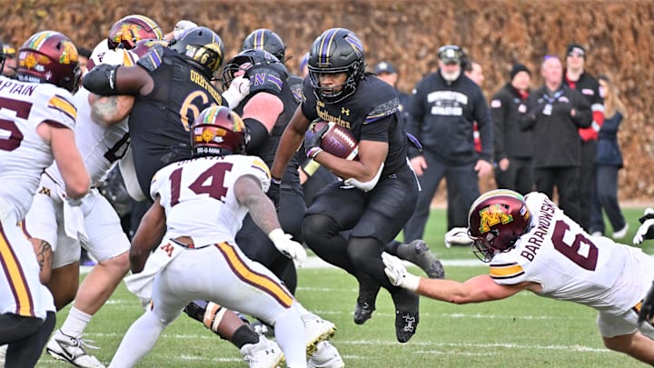 Nov 22, 2025; Chicago, Illinois, USA; Northwestern Wildcats running back Caleb Komolafe (5) runs the ball against the Minnesota Golden Gophers during the second half at Wrigley Field. Mandatory Credit: Patrick Gorski-Imagn Images