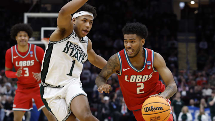 Mar 23, 2025; Cleveland, OH, USA; New Mexico Lobos guard Donovan Dent (2) dribbles the ball defended by Michigan State Spartans guard Jeremy Fears Jr. (1) in the second half during the NCAA Tournament Second Round at Rocket Arena. Mandatory Credit: Rick Osentoski-Imagn Images