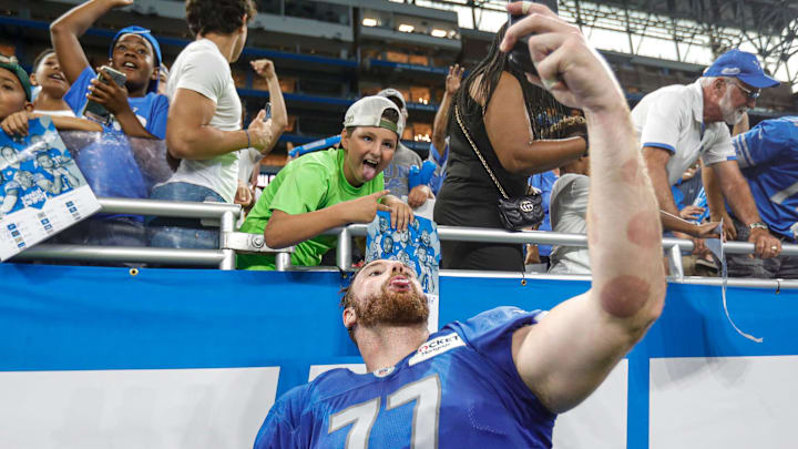 Detroit Lions center Frank Ragnow takes a selfie with fans after open practice at Family Fest at Ford Field in Detroit on Saturday, Aug. 6, 2022.