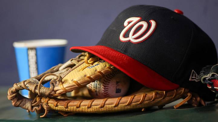 Dark blue Washington Nationals hat on top of light brown mitt