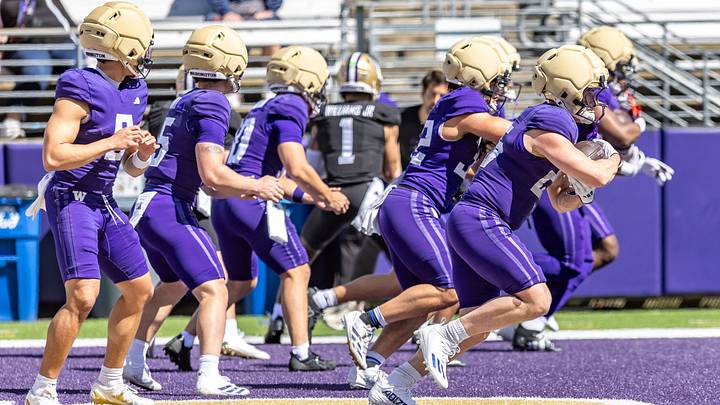Husky quarterbacks and running backs share in a spring drill. 