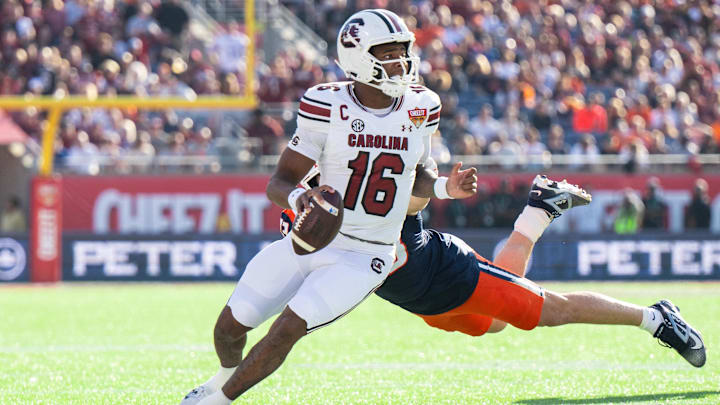 Dec 31, 2024; Orlando, FL, USA; South Carolina Gamecocks quarterback LaNorris Sellers (16) runs the ball against Illinois Fighting Illini linebacker Joe Barna (43) in the first quarter at Camping World Stadium. Mandatory Credit: Jeremy Reper-Imagn Images