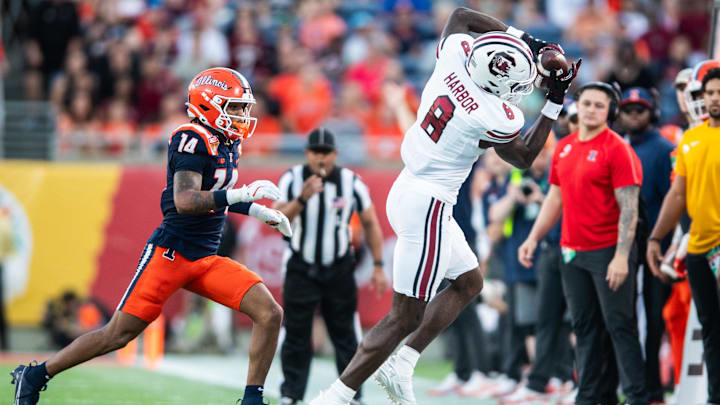 Dec 31, 2024; Orlando, FL, USA; South Carolina Gamecocks wide receiver Nyck Harbor (8) makes the catch over Illinois Fighting Illini defensive back Xavier Scott (14) in the third quarter at Camping World Stadium. Mandatory Credit: Jeremy Reper-Imagn Images