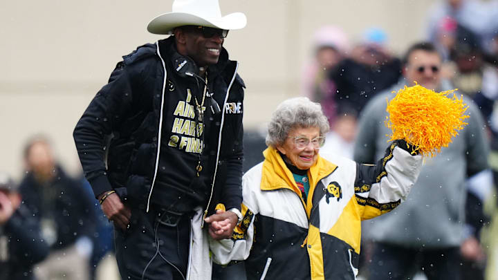 Colorado Buffaloes head coach holds the hand of fan Peggy Coppom before the start of the spring game at Folsom Field.
