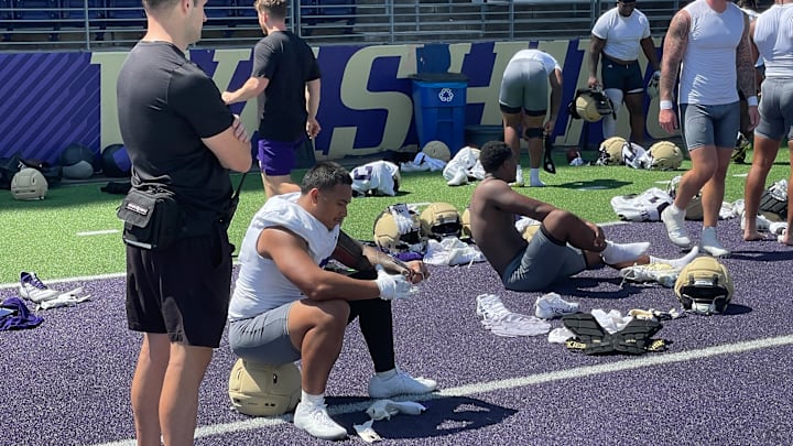 Jacob Manu sits after his first UW practice and his teammates step into ice baths. 