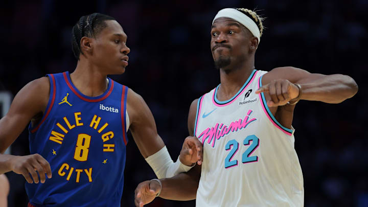 Jan 17, 2025; Miami, Florida, USA; Miami Heat forward Jimmy Butler (22) reacts as Denver Nuggets forward Peyton Watson (8) defends during the fourth quarter at Kaseya Center. Mandatory Credit: Sam Navarro-Imagn Images